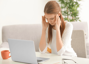 a woman sitting at a table with a laptop