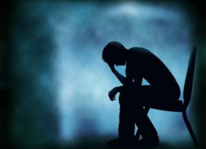 a man sitting on a chair in the dark