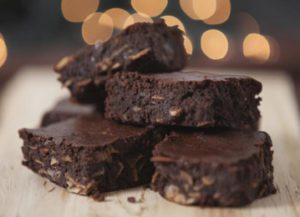 a pile of brownies sitting on top of a wooden cutting board