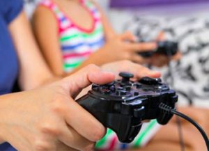 two girls playing video games with remote controllers