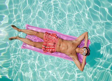 a man laying on an inflatable mattress in the water