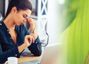 a woman sitting at a table with a laptop computer