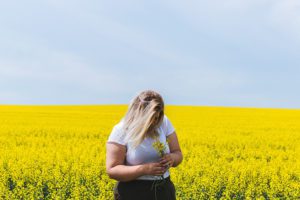 a woman standing in a field of yellow flowers