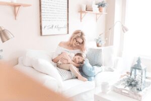 a woman and child are sitting on a couch