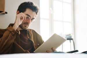 a man sitting at a table reading a book