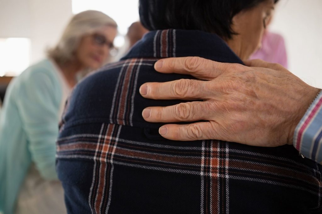 an older woman is holding her hands on her back