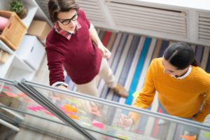 two people are walking down an escalator