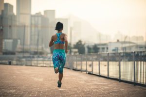 a woman running on a brick road in front of a city skyline