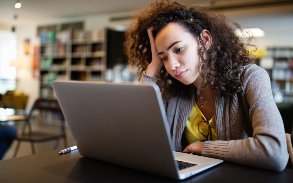 a woman sitting in front of a laptop computer