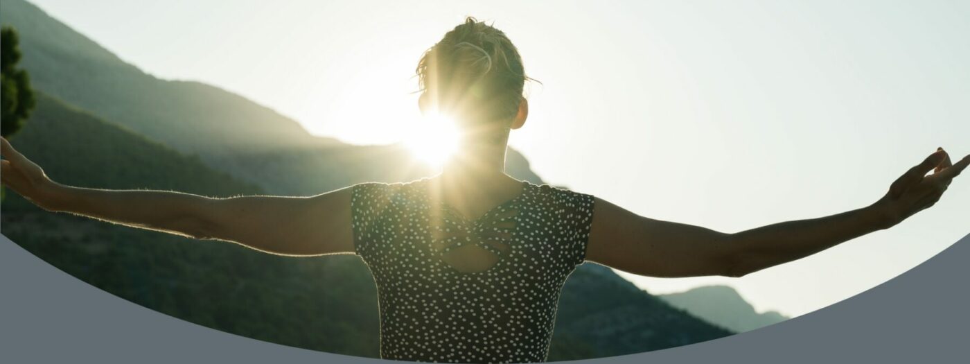 a person with their arms outstretched in front of the sun