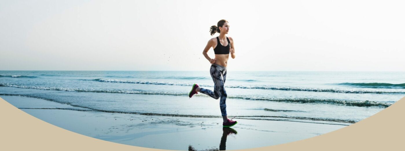 a woman is running on the beach near the water
