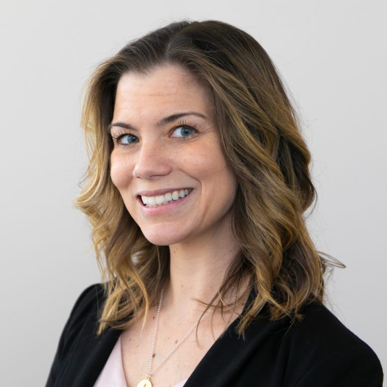 a woman smiling and wearing a black jacket