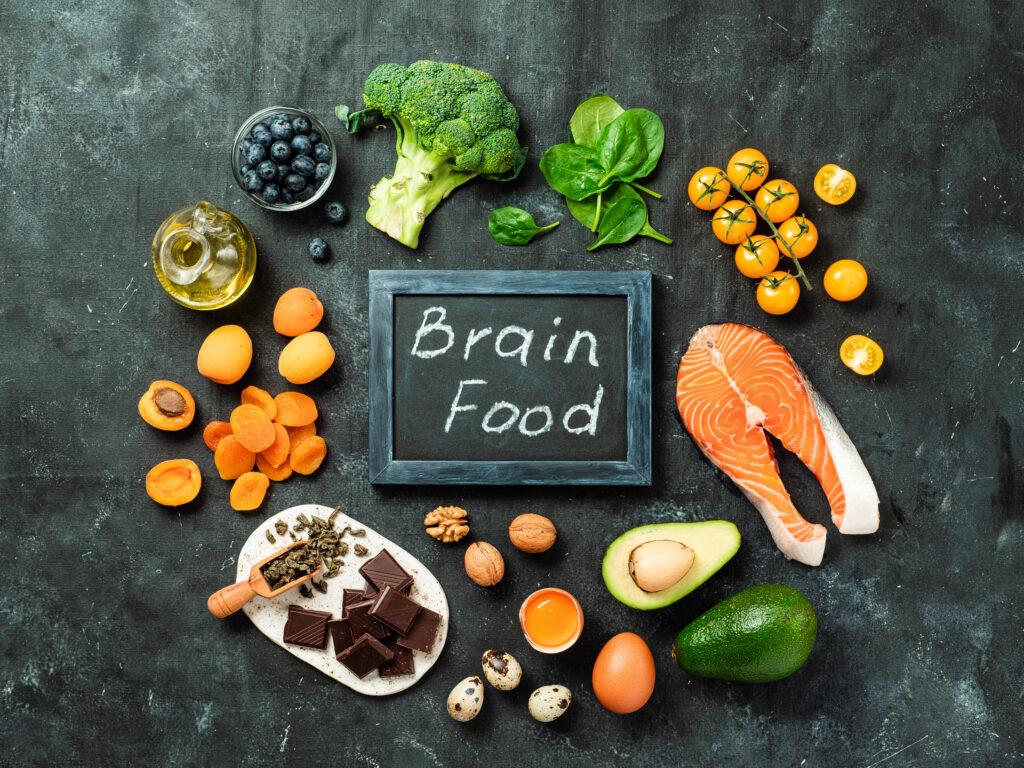 a blackboard with the words brain food surrounded by fruits and vegetables